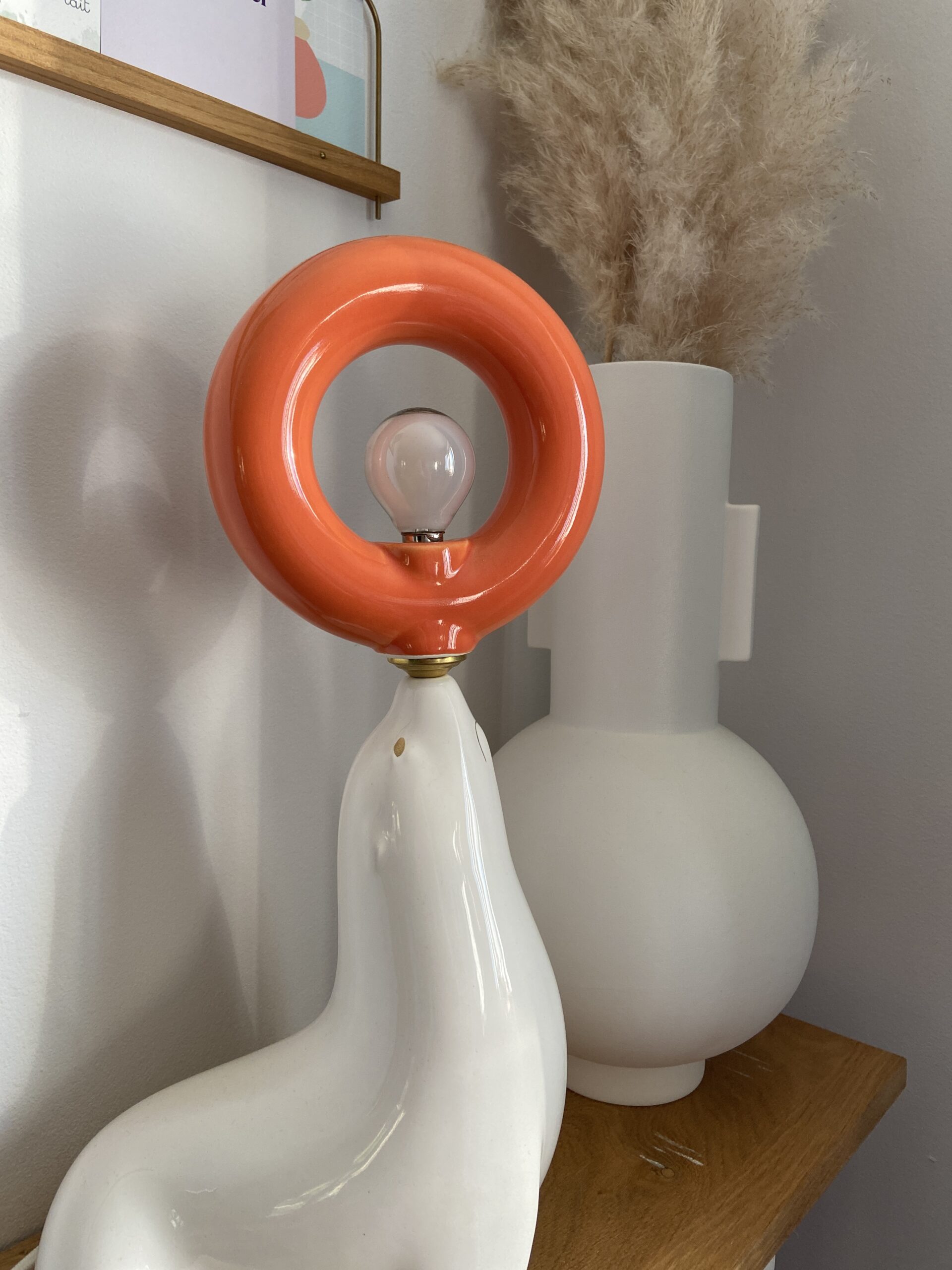 Salle de réunion avec table en bois, chaise moderne, mur blanc et plante verte tombante